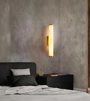Modern marble wall light installed beside a bedroom setup