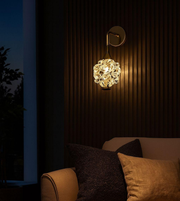 Luxury crystal flower wall sconce with brushed gold arm mounted on modern wall