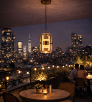 Modern amber glass cylinder pendant light with inner LED tube hanging in luxury dining setting at night