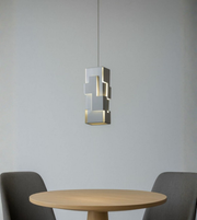 Modern grey geometric column pendant light above dining table with soft ambient lighting
