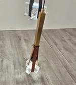 Decorative object with a gold rod and brown base on a wooden floor