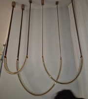 Rope swing hanging from the ceiling against a white wall