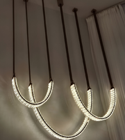 Modern pendant lights hanging from the ceiling with a neutral background.