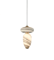 CLOSE UP OF Modern marble-effect glass pendant light with sculptural double-form design, brushed brass accents, and warm ambient illumination.
