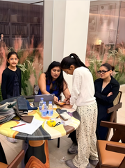 Group of people discussing decor and material samples at a modern designer table indoors