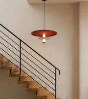 Modern pendant light above minimalist wooden staircase with black metal railing