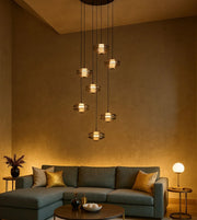 Modern living room with pendant chandelier, green sectional sofa, and gold accent decor