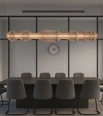 Modern linear pendant light above black conference table with gray chairs in minimalist office