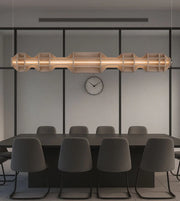 Modern linear pendant light above black conference table with gray chairs in minimalist office